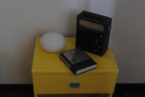 ein Schreibtisch mit einem Radio und einem Buch darauf in der Unterkunft Dimora Romano in Alberobello