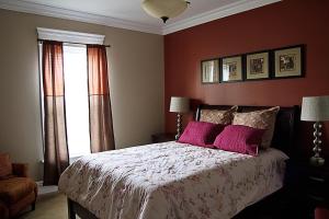1 dormitorio con 1 cama grande con almohadas moradas en Wishmaker House B&b, en Bellville