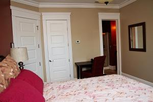 1 dormitorio con cama, mesa y escritorio en Wishmaker House B&b, en Bellville