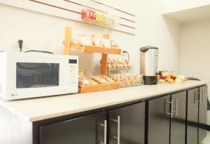 eine Küchentheke mit Mikrowelle und etwas Brot in der Unterkunft Hotel Fiesta Versalles in Monterrey