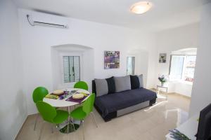 a living room with a couch and a table at Apartmani Cindrić in Karlobag