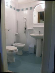 a white bathroom with a toilet and a sink at Alla Basilica in Aquiléia