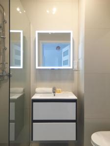 Baño blanco con lavabo y espejo en Apartamenty Metro Słodowiec, free parking Żeromskiego 1 CMKP- 5 min, en Varsovia