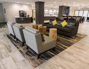 a lobby with couches and chairs in a hotel at Wingate by Wyndham Dallas Love Field in Dallas