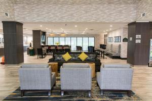 a lobby with a couch and chairs and a table at Wingate by Wyndham Dallas Love Field in Dallas