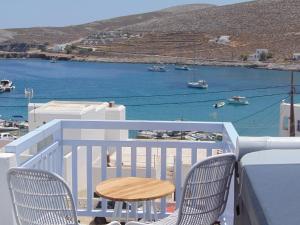 a balcony with two chairs and a view of the water at AMO Folegandros in Karavostasi
