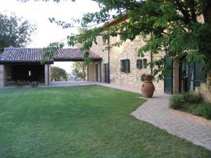 a courtyard of a stone house with a large yard at Azienda Agraria Montelujano in Gubbio