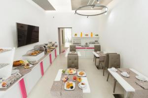 a room with tables and chairs and a kitchen at Hotel Nunù in Naples