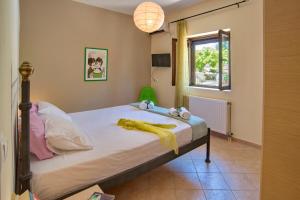 a bedroom with a bed with a yellow blanket on it at Villa Kiki Paxos Ozias in Gaios