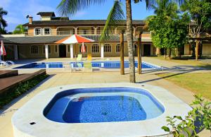 a swimming pool in front of a house at Pousada Porto do Rio in Caraguatatuba