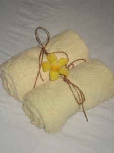 a yellow flower sitting on top of two towels at Rim Ping Guest House in Chiang Mai