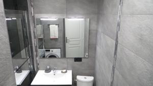 a bathroom with a sink and a mirror and a toilet at Catalans in Marseille