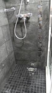 a bathroom with a shower with a tile floor at Catalans in Marseille