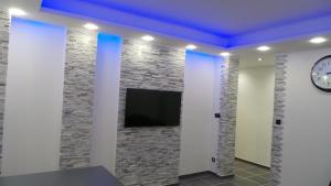 a room with a tv on a stone wall at Catalans in Marseille