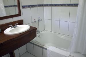 a white bathroom with a sink and a bath tub at Hotel Bosque Verde Lodge in Monteverde Costa Rica