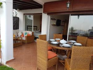 a patio with a table and chairs and a couch at Cabobeach Appartement in Cabo Negro