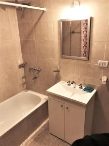 a bathroom with a sink and a tub and a mirror at Congreso Centro in San Miguel de Tucumán