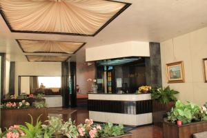 un hall avec des fleurs et des plantes dans un bâtiment dans l'établissement Hotel Palm Beach, à Lido di Jesolo