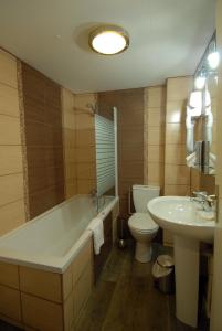 La salle de bains est pourvue d'une baignoire, de toilettes et d'un lavabo. dans l'établissement Logis - Hôtel & Restaurant Le Bellevue, à La Bouille