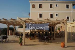 a restaurant with tables and chairs in front of a building at La Sapienza in Methoni