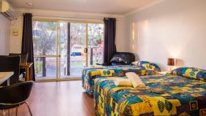 a hotel room with two beds and a window at Australind Tourist Park in Australind