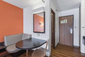 a small room with a table and a mirror at Motel 6 Omaha - Central in La Vista