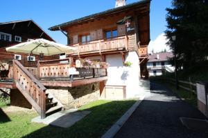 a house with an umbrella on the side of it at Chalet Marie Claire in Notre-Dame-de-Bellecombe