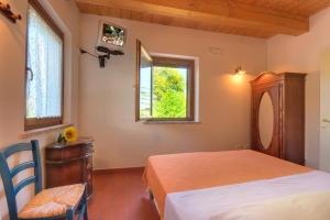 a bedroom with a bed and a chair and a window at Agriturismo Azzurro in Osimo