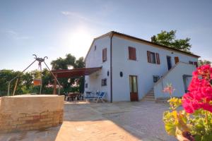 a white house with a patio and a table at Agriturismo Azzurro in Osimo