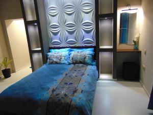 1 dormitorio con 1 cama con edredón azul en Georgievi Guest House, en Sapareva Banya