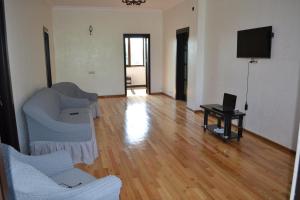 a living room with two chairs and a flat screen tv at Shalva Apartment in Chakvi