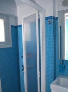 uma casa de banho azul com um chuveiro e um lavatório em Anthousa Hotel em Apollonia