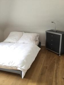 - une chambre avec un lit blanc et une table de nuit dans l'établissement Apartment am Klinikum, à Cassel