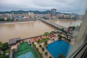 a view of a river with a city and a bridge at Ramada Plaza Shaoguan City Centre in Shaoguan