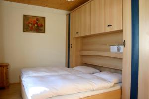 łóżko w pokoju z drewnianą ścianą w obiekcie Austrian Alps - Haus Kienreich w mieście Altenmarkt im Pongau