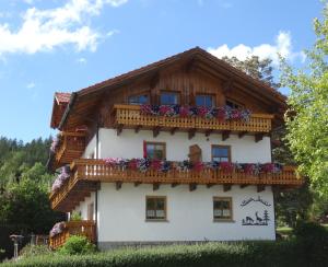 a house with a balcony with flowers on it at Haus Seidl in Bodenmais