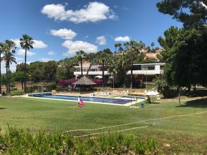 a person walking in a park next to a swimming pool at Buenavista Apartment in Sitges