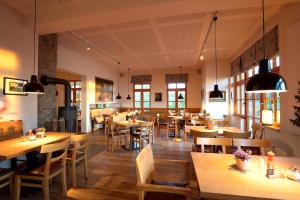 a restaurant with wooden tables and chairs and windows at Plumbohms Aussichtsreich Gast- und Logierhaus in Bad Harzburg