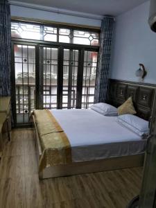 a bedroom with a large bed with a large window at 166 Inn in Fenghuang