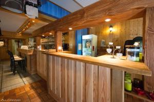 a bar in a restaurant with wooden walls at chalet des cyclistes in La Bresse