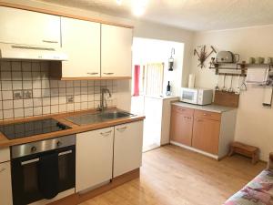 Una cocina con gabinetes blancos y un fregadero. en Austrian Alps - Haus Kienreich, en Altenmarkt im Pongau 21 fotos más