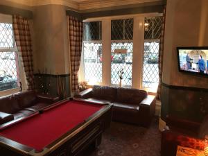 a living room with a pool table and a tv at West Vale Villa in Blackpool
