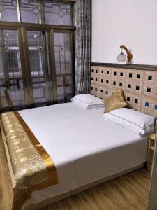 a bed with two pillows on it in a room at 166 Inn in Fenghuang
