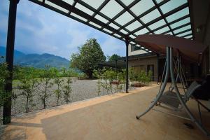 a chair on a patio with a view of a house at Shan Jhong You You B&B in Lugu Lake