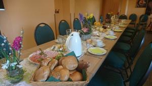 ein langer Tisch mit einem langen Tisch mit Brot und Blumen in der Unterkunft Heidebistro in Commerau