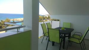 a balcony with a table and chairs and the ocean at Apartmani Vila Dadić in Karlobag