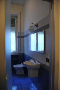 ピオンビーノにあるAppartamento di pregioの青と白のバスルーム(洗面台、トイレ付)