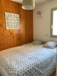 Un dormitorio con una cama y una pared de madera. en Appartement tt confort au cœur des montagnes avec vue sur les montagnes wifi, en Luz-Saint-Sauveur 46 fotos más
