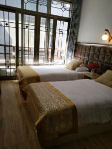 a hotel room with two beds and a large window at 166 Inn in Fenghuang