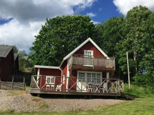 蒂纳Vimmerby Lilla utsikten的红色的房子,上面设有阳台